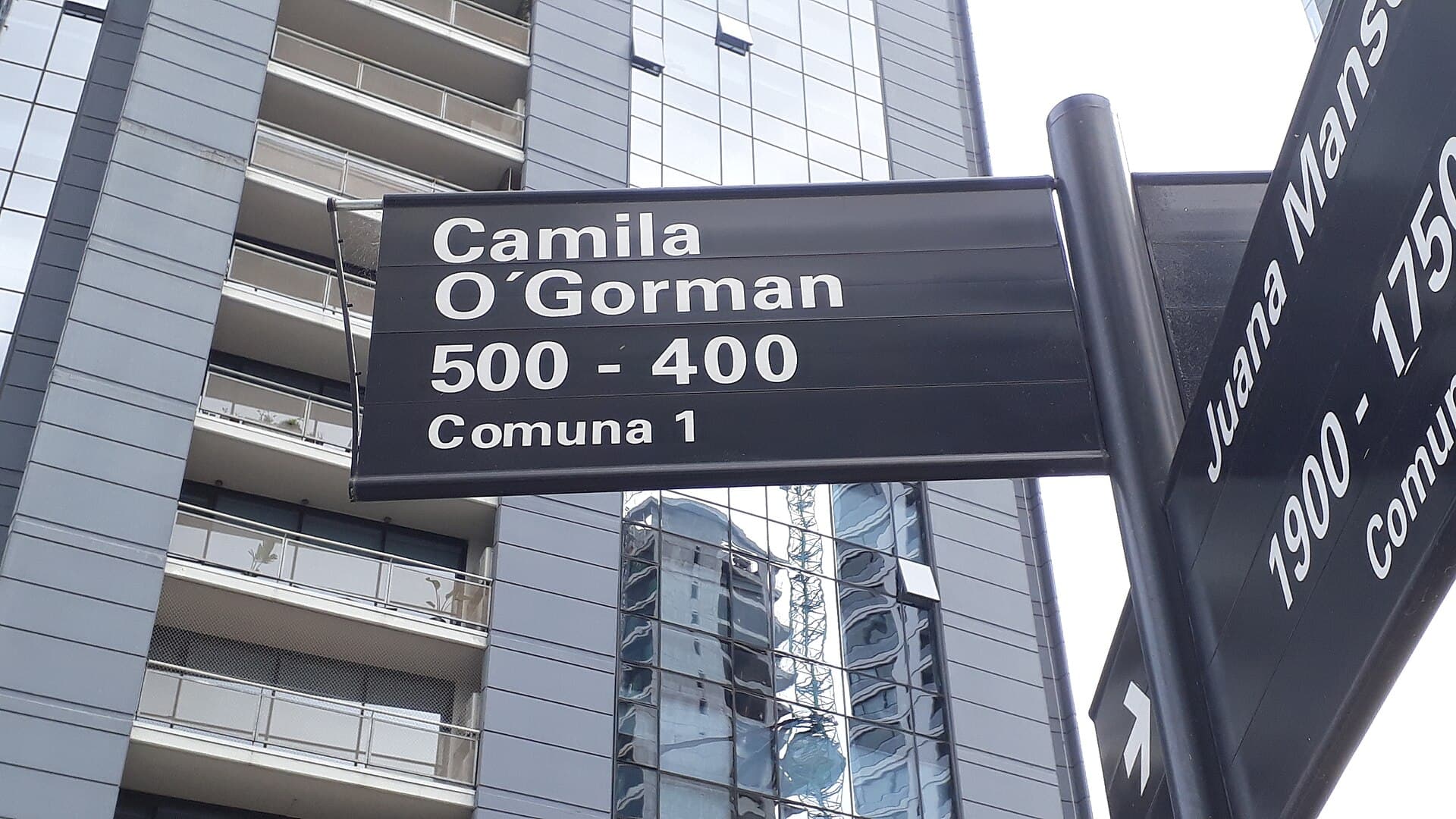 Buenos Aires travel planning photo showing Nomenclatura urbana con nombre femenino de la Ciudad Autónoma de Buenos Aires, barrio de Puerto Madero, Argentina. Detrás, la torre Art Marí