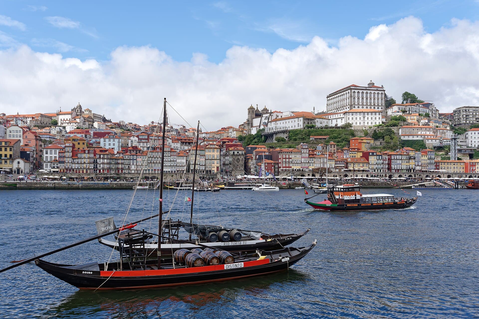 Porto travel planning photo showing rabelo boats on the Douro with Ribeira and Porto Cathedral behind them