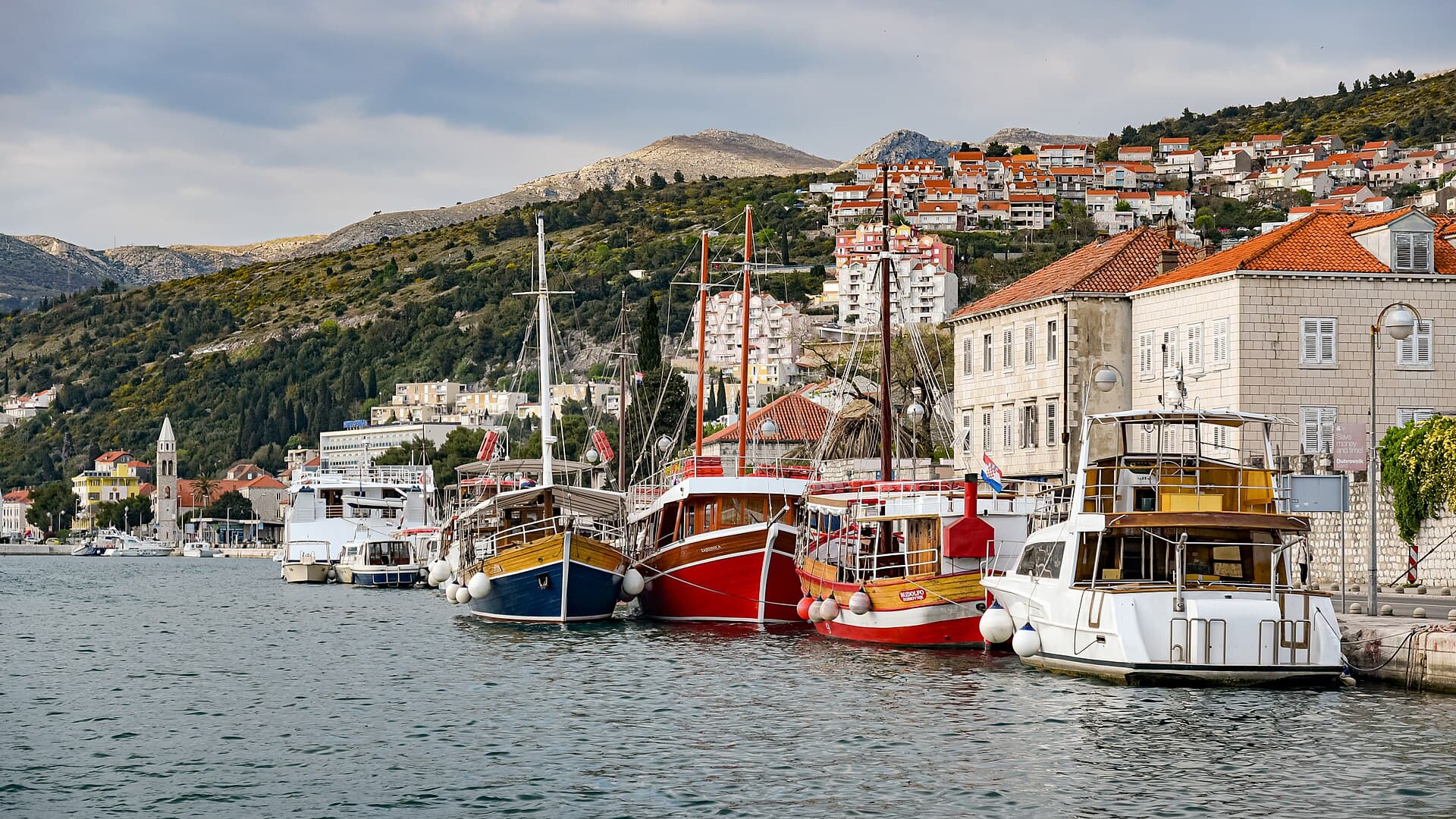 Port of Gruz in Dubrovnik with ferries, waterfront buildings, and hillside neighborhoods